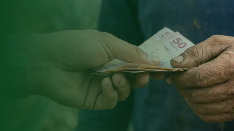 Productor rural recibiendo pago directo en billetes por la venta de su cosecha.